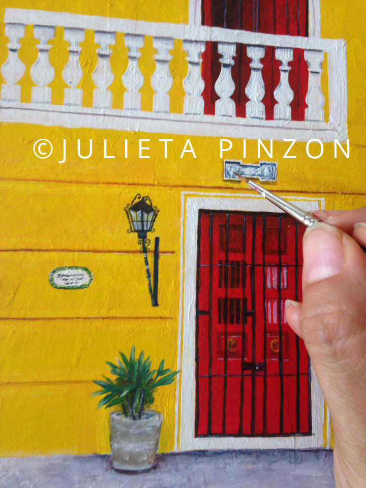 Yellow house in Merida City painted on a small wooden box. Front door and hand painting details